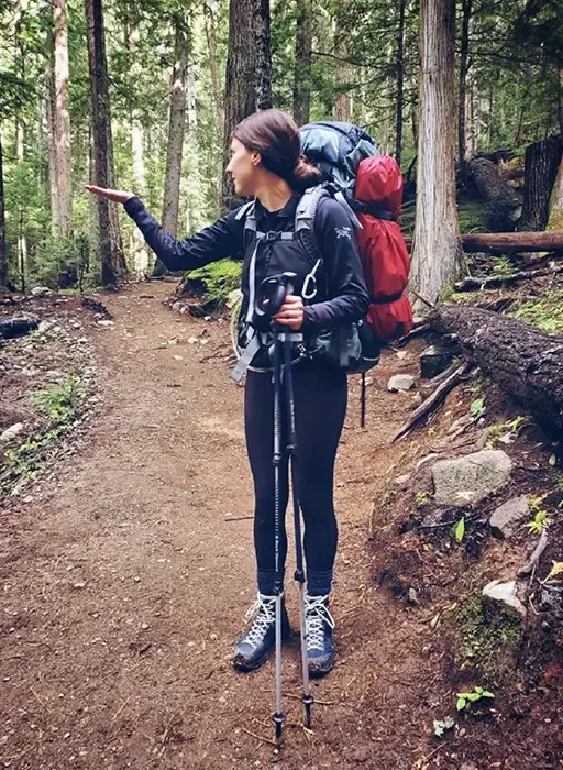 Adrianne hiking in a forest setting, representing outdoor wellness, grounding, and personal resilience