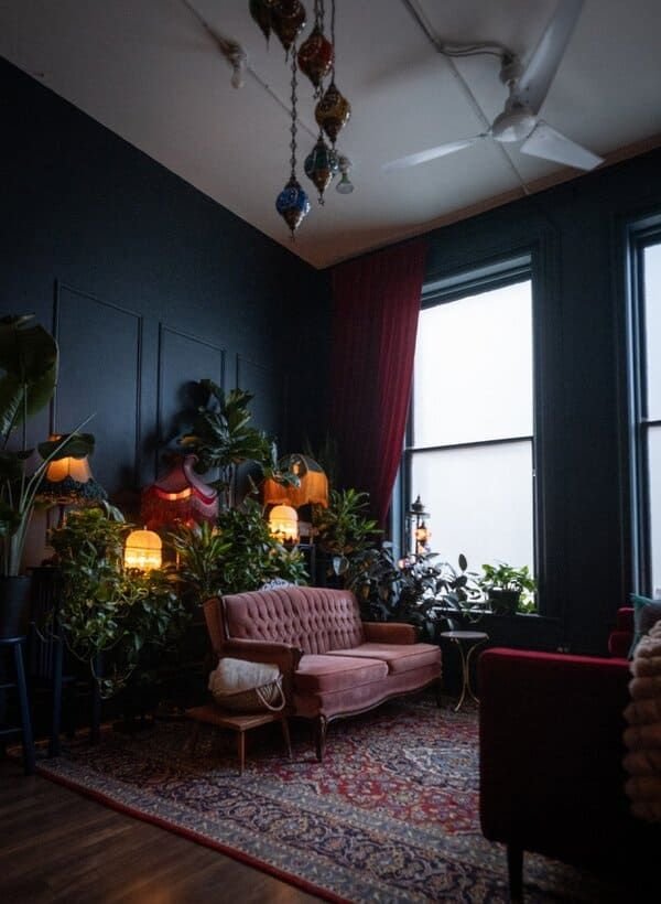 Warm and inviting therapy room with a pink loveseat, soft lighting, plants, and cozy decor, representing a safe space for partner therapy.