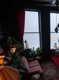 Welcoming therapy space with a pink sofa, plants, warm lamps, and comfortable seating