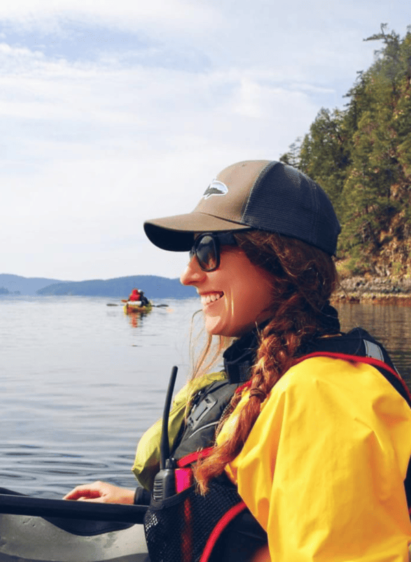 Teen smiling while kayaking on a calm lake, representing confidence, emotional growth, and therapy support for teens